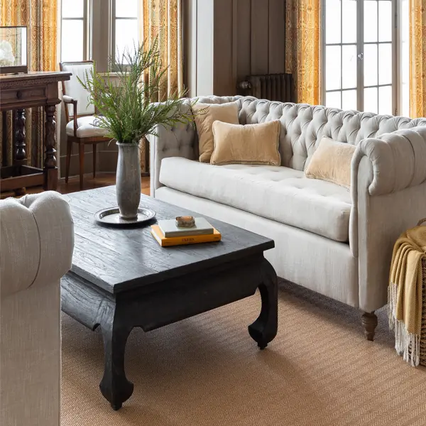 Patterned yellow curtains framing large windows in a cozy living room.
